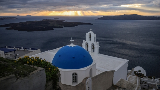 The sun sets behind Three Bells church in the village of Firostefani, as the increased seismic activity continues on the island of Santorini, Greece.(Image by REUTERS/Louisa Gouliamaki)
