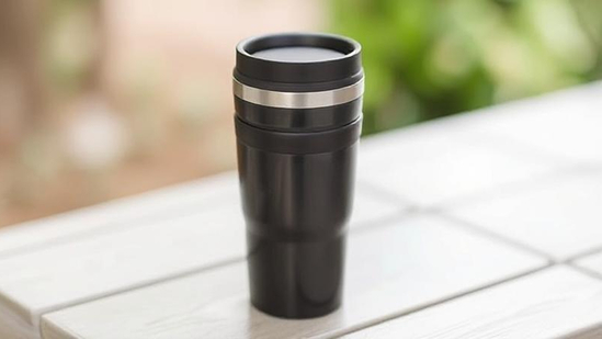 Stylish travel mug keeps drinks hot or cold on adventures.