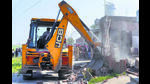 Police demolishing illegal structures of two drug smugglers in Talwandi Kalan village in Ludhiana on Tuesday. (HT Photo) Police demolishing illegal structures of two drug smugglers in Talwandi Kalan village in Ludhiana on Tuesday. (HT Photo)