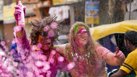 Foreign tourists participate in Holi celebrations along with locals in Paharganj, in New Delhi.(PTI)