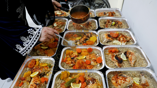 A Palestinian woman who was evacuated from Gaza, prepares Iftar meals, during the holy month of Ramadan, in Doha, Qatar. (Image by REUTERS/Ibraheem Abu Mustafa)