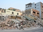 A woman walks past destroyed buildings in Mandalay on April 1, 2025, four days after a major earthquake struck central Myanmar.(AFP) A woman walks past destroyed buildings in Mandalay on April 1, 2025, four days after a major earthquake struck central Myanmar.(AFP)