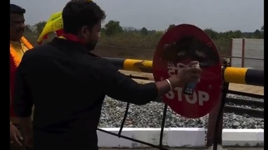 A Kannada activist painting the railway sign board with black paint. A Kannada activist painting the railway sign board with black paint.