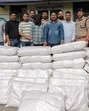 The police with the arrested individuals and the cannabis consignment. (Sourced photo) The police with the arrested individuals and the cannabis consignment. (Sourced photo)