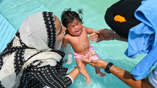 Even children are carefully dipped for the blessings on the auspicious day of Baisakhi.(HT/@Sanchit Khanna)