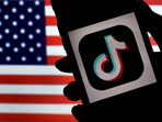 In this photo illustration, the social media application logo, TikTok is displayed on the screen of an iPhone on an American flag background on August 3, 2020 in Arlington, Virginia.(AFP) In this photo illustration, the social media application logo, TikTok is displayed on the screen of an iPhone on an American flag background on August 3, 2020 in Arlington, Virginia.(AFP)