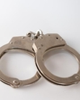 A high angle shot of metal handcuffs isolated on a white background A high angle shot of metal handcuffs isolated on a white background