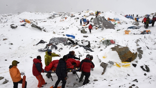 In this photograph, rescuers use a makeshift stretcher to carry an injured person after an avalanche triggered by an earthquake flattened parts of Everest Base Camp. Nepal cracks down: Only elite climbers will touch Everest’s summit.(Photo by Roberto SCHMIDT / AFP) In this photograph, rescuers use a makeshift stretcher to carry an injured person after an avalanche triggered by an earthquake flattened parts of Everest Base Camp. Nepal cracks down: Only elite climbers will touch Everest’s summit.(Photo by Roberto SCHMIDT / AFP)