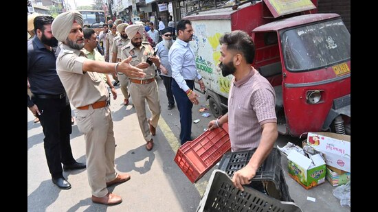Police personnel removing the illegal encroachment from the Field Ganj in Ludhiana on Wednesday. (HT Photo) Police personnel removing the illegal encroachment from the Field Ganj in Ludhiana on Wednesday. (HT Photo)