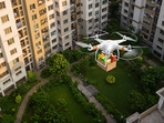 An apartment complex in South Bengaluru now receives groceries, medicines, and daily essentials through drone deliveries. (Representational Image)(AI-generated image created by Gemini ) An apartment complex in South Bengaluru now receives groceries, medicines, and daily essentials through drone deliveries. (Representational Image)(AI-generated image created by Gemini )