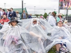 Guests huddle under a large plastic bag for cover as they watch the races ahead of the 151st running of the Kentucky Derby at Churchill Downs on May 3, 2025, in Louisville, Kentucky. (Photo by LEANDRO LOZADA / AFP)(AFP) Guests huddle under a large plastic bag for cover as they watch the races ahead of the 151st running of the Kentucky Derby at Churchill Downs on May 3, 2025, in Louisville, Kentucky. (Photo by LEANDRO LOZADA / AFP)(AFP)