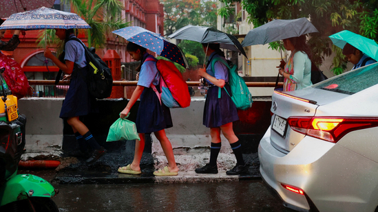 School children use umbrellas to cover themselves from the rain as they walk to school, in New Delhi. (REUTERS file)