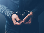 Arrested computer hacker and cyber criminal with handcuffs, close up of hands. (iStockphoto)