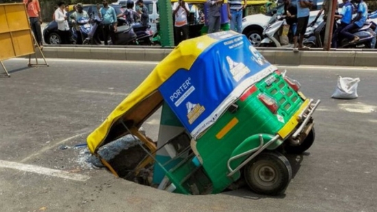 The autorickshaw plunged front-first into a sinkhole on Makarba Main Road, Ahmedabad. (X) The autorickshaw plunged front-first into a sinkhole on Makarba Main Road, Ahmedabad. (X)