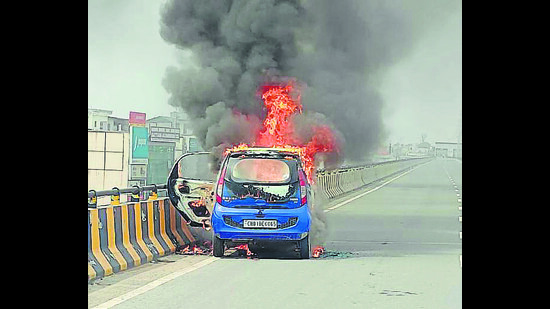 The Tata Nano car ablaze on the Zirakpur flyover on the Chandigarh-Ambala highway on Tuesday. (HT Photo) The Tata Nano car ablaze on the Zirakpur flyover on the Chandigarh-Ambala highway on Tuesday. (HT Photo)
